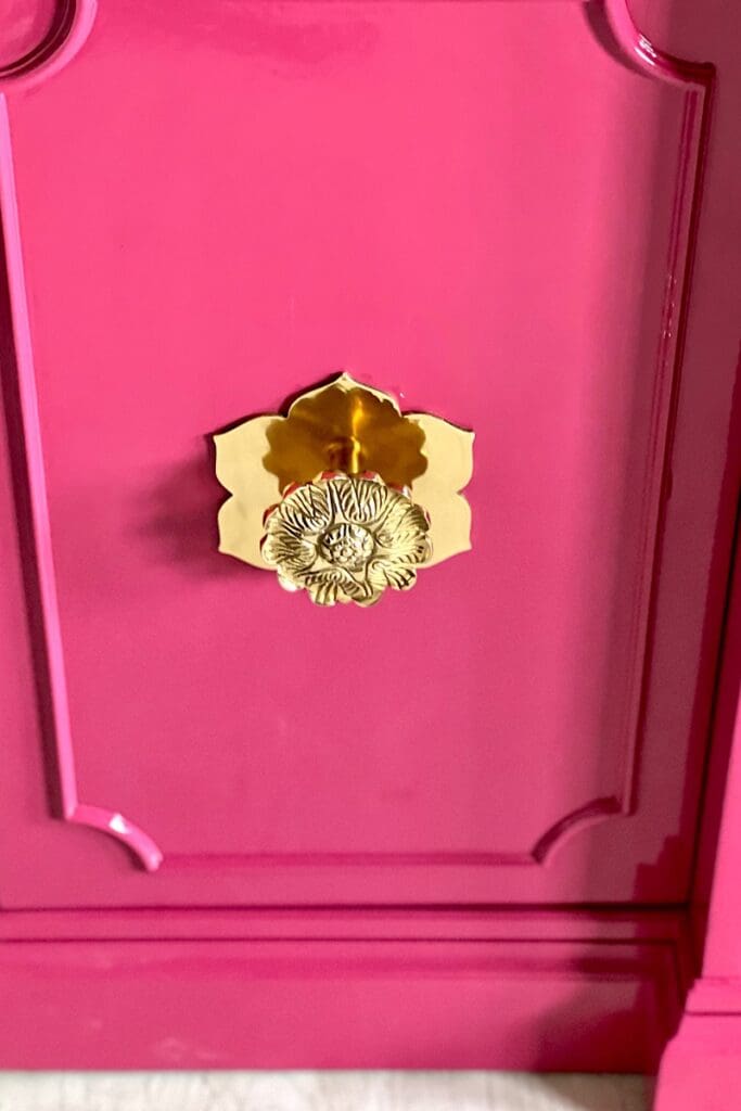 Brass knobs on pink china cabinet 